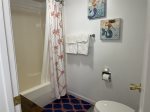 Powder room with toilet and shower/tub enclosure